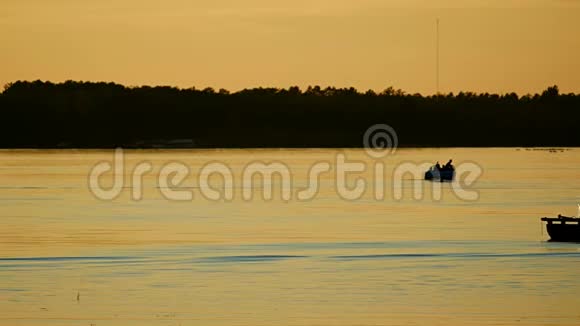 明尼苏达州贝米吉平静的湖面上划船的人们剪影视频的预览图