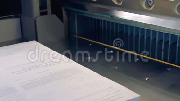 一名工人的特写镜头把纸放进剪纸工业机器4K视频的预览图