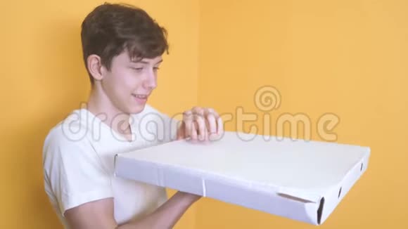 有披萨盒概念的快乐少年男孩打开一盒美味的披萨欢乐想吃披萨快餐视频的预览图