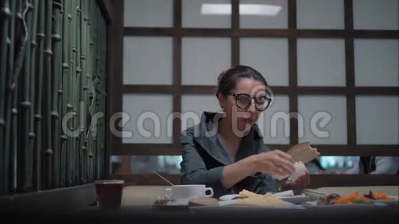 年轻女子戴着时髦眼镜吃午餐视频的预览图