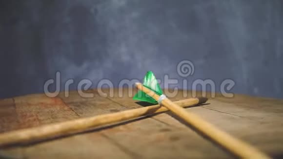 旋转圆木桌上的老绿色木箭美丽的深色背景视频的预览图