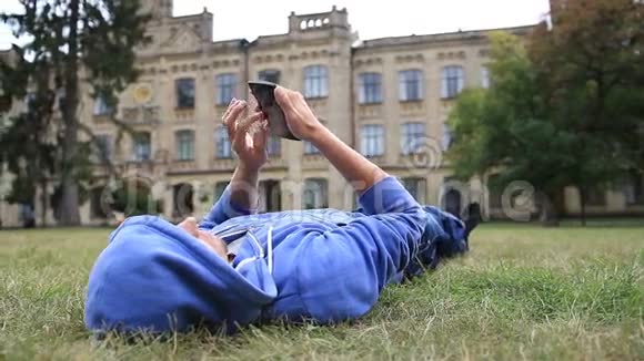 年轻男学生浏览智能手机视频的预览图