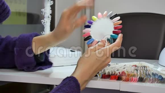 美容店的女性客户双手整齐在指甲调色板上选择颜色视频的预览图