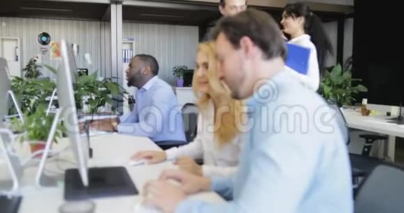 商务人士在现代创意办公室的电脑桌上讨论报告商务人士团队会议视频的预览图
