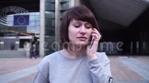 这位女士正在布鲁塞尔欧洲议会附近散步和打电话比利时视频的预览图