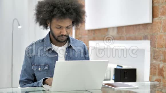 非洲男人在笔记本电脑上打字视频的预览图