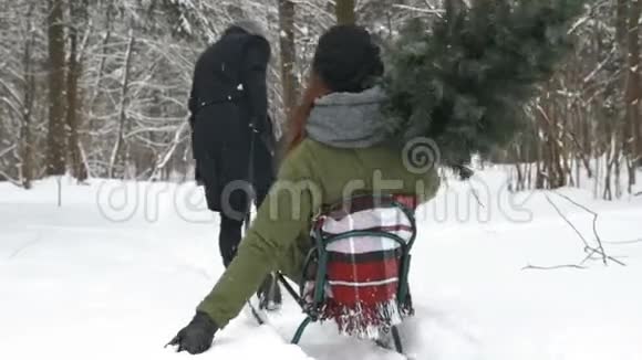 男人在雪地上拉着女孩冬季乐趣视频的预览图