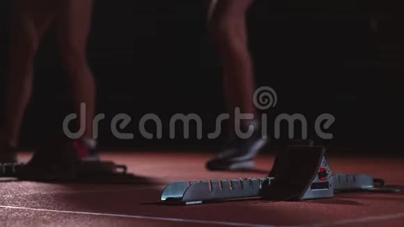 田径场的女跑运动员在比赛前蹲在起点动作缓慢视频的预览图