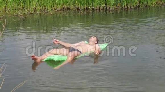在炎热的夏日里休息在床垫上的河中游泳视频的预览图