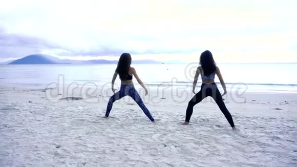 身材苗条的妇女在海上从事体操活动视频的预览图