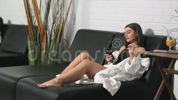 一个穿着浴袍的女孩在水疗中心的休息室里视频的预览图
