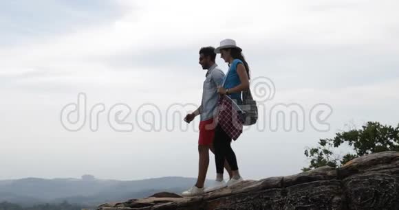 情侣漫步山上的男女牵着手看风景晨曦中的天际线游客旅游视频的预览图
