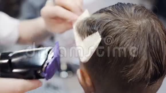 快关门专业的理发师在海脊和电动剃须刀的帮助下在湿发上做了一个新的理发男子视频的预览图