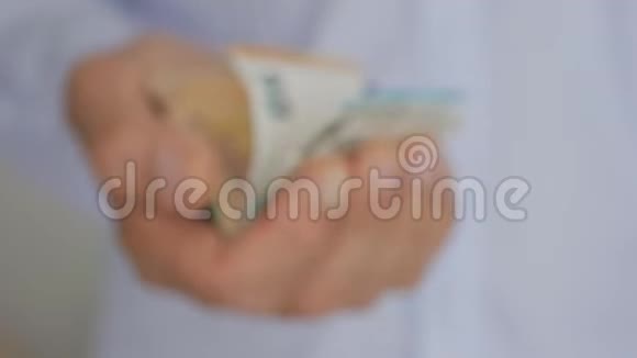 一个穿着淡蓝色衬衫的成熟男人的手手里拿着欧元纸币视频的预览图