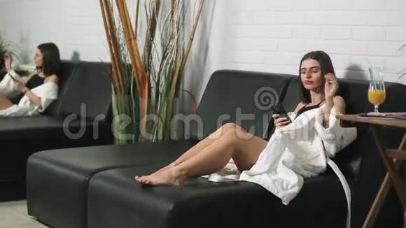 一个穿着浴袍的女孩在水疗中心的休息室里视频的预览图