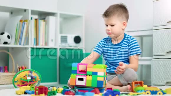 一个可爱的男孩正在家里玩塑料建筑视频的预览图