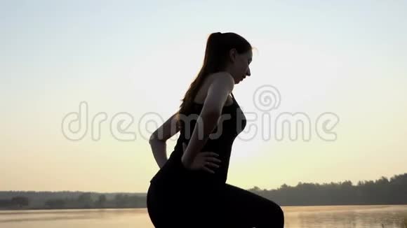 4k湖岸日落时年轻的怀孕少女会在日落时分裂蹲吗视频的预览图