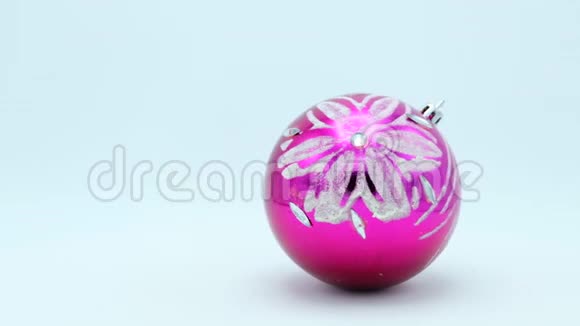 圣诞节粉红色的球银光闪闪的花在白色的背景上旋转视频的预览图