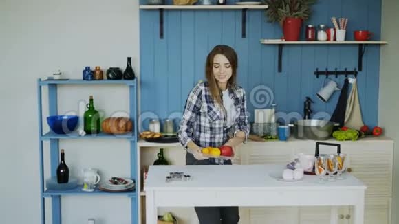 快乐的年轻有趣的女人在家里的厨房里跳舞唱歌摆桌子吃早餐视频的预览图
