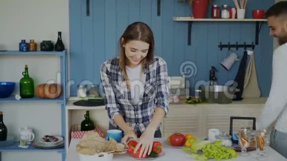 可爱的情侣在厨房里玩得很开心英俊的男人玩弄水果来打动他的女朋友视频的预览图