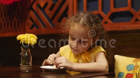 孩子坐在咖啡馆吃奶酪蛋糕快关门视频的预览图