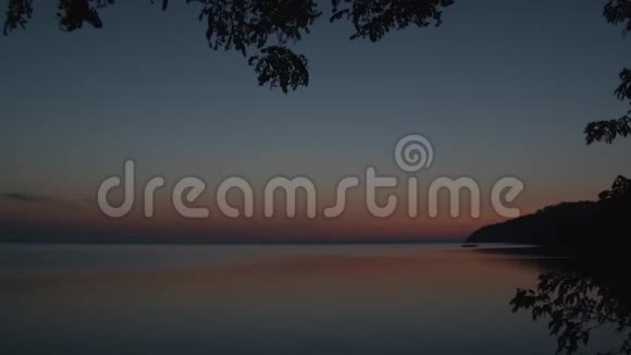 日出时美丽的湖泊或河流前景中有一根树枝视频的预览图