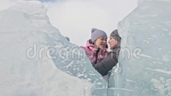 在冰封的湖面上年轻夫妇在冬天散步时玩得很开心爱情故事恋人们躲在冰后视频的预览图