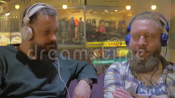 两个留着胡子的男人用耳机听音乐视频的预览图