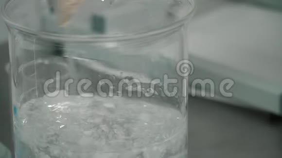 科学家在实验室将液体与白色薄片混合视频的预览图