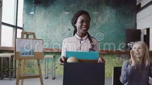 最近被雇来做公司工作的年轻非洲妇女进入了新的办公室女性手提箱子里有私人物品视频的预览图