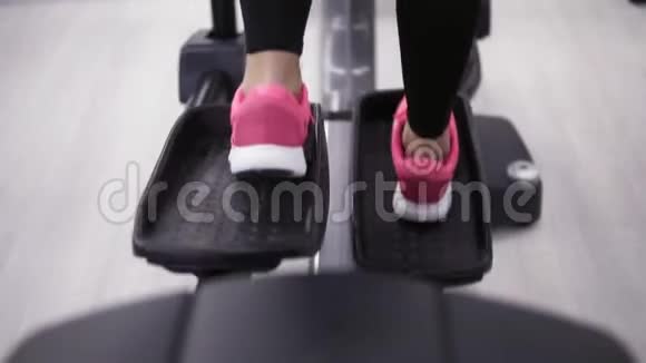 穿着粉色运动鞋的女性腿在轨道模拟器上蹬视频的预览图