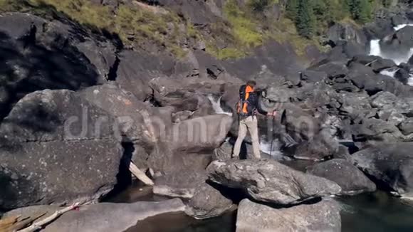 空中观景人站在瀑布河前有岩石树木视频的预览图