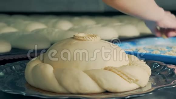 面包师用一块面团装饰一块圆面包把盘子转过来关上视频的预览图