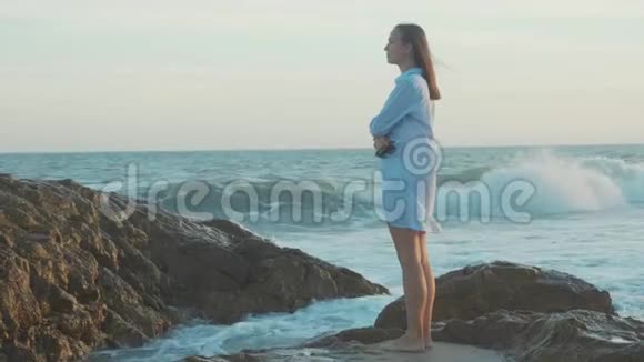 年轻女子站在沙滩上缓慢地看着大海视频的预览图