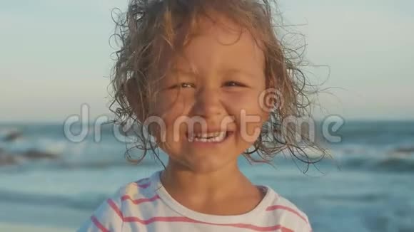 站在海滩上美丽的小女孩的肖像视频的预览图