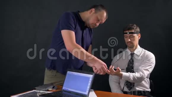 一个男人看着他的手指安装了测谎仪4k60fps视频的预览图