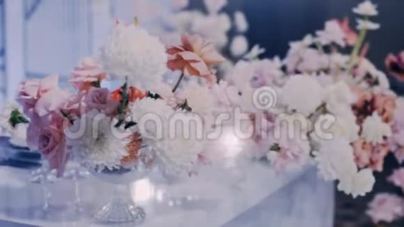 蓝色背景下水晶花瓶中婚礼花束的中间特写镜头视频的预览图