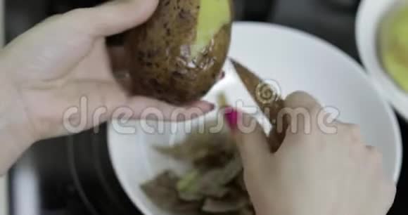 女家庭主妇在厨房里用手剥土豆视频的预览图