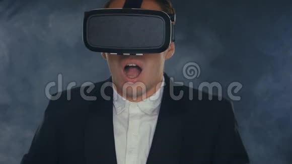 年轻的商人在烟雾弥漫的黑色房间里使用虚拟现实眼镜视频的预览图
