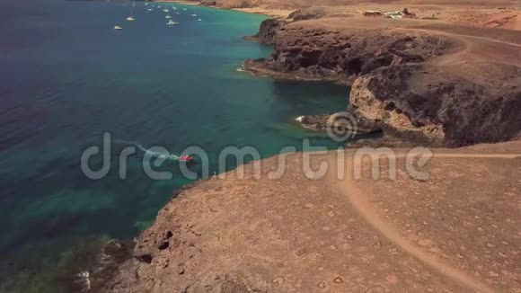 鸟瞰锯齿状的海岸和海滩兰萨罗特西班牙加那利红色的小艇停泊在海湾里帕帕加伊视频的预览图