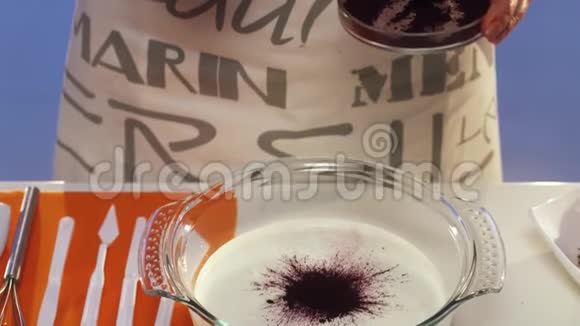 小盘子里的深紫色面粉撒在玻璃平底锅里的酸奶油上视频的预览图
