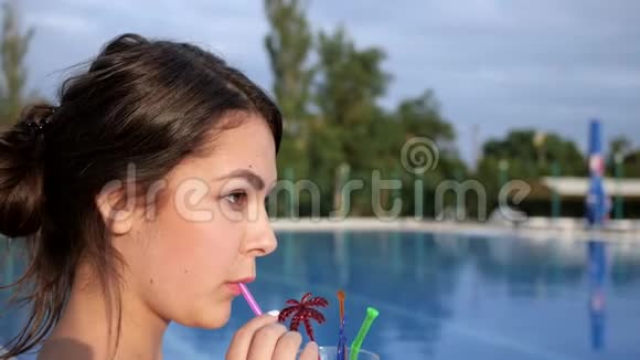 吸引人的女孩在暑假附近的Poolside喝鸡尾酒视频的预览图