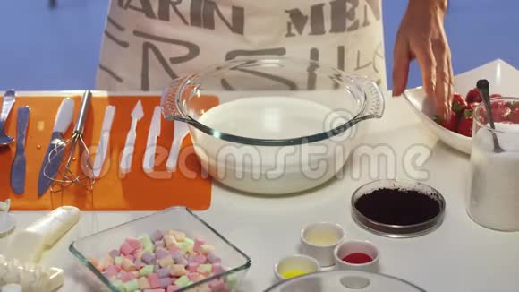小盘子里的深紫色粉撒在玻璃平底锅里的酸奶油上视频的预览图