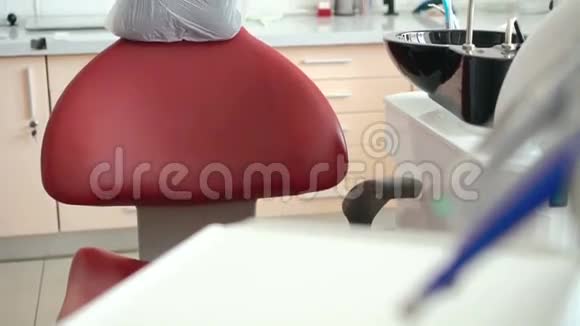 可爱的女孩坐在牙医椅上在相机上微笑慢慢地视频的预览图