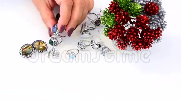 女人触摸宝石和贱金属玻璃装饰石黄玉和月光石智能手机视频的预览图