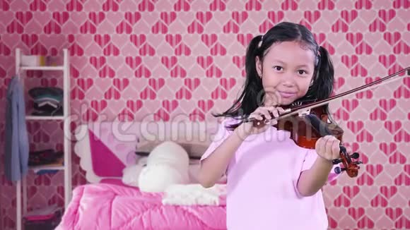 可爱的女孩在卧室拉小提琴视频的预览图