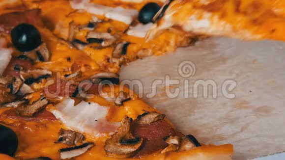 意大利大比萨饼有黑色橄榄培根腊肠和奶酪一块比萨饼被咬了视频的预览图