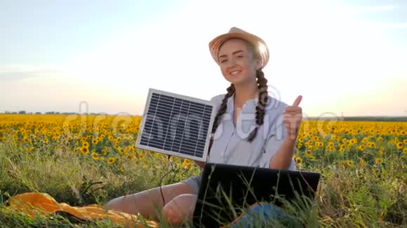 肖像女孩在露天手持太阳能电池板女性在带笔记本充电器的背光中视频的预览图