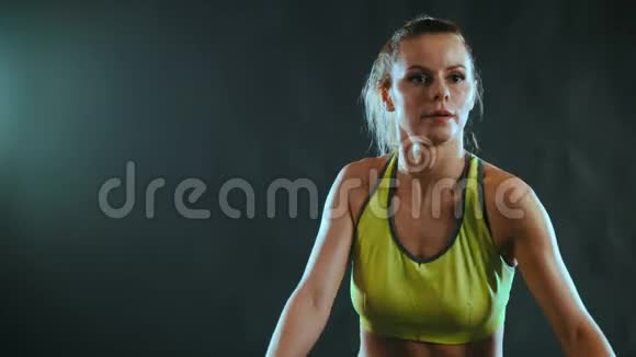 一个穿着运动服的年轻迷人的女人增强了健身俱乐部的肌肉视频的预览图