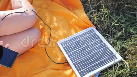 一种能产生能量的技术靠近手女孩从太阳能电池板连接到外面的手机视频的预览图